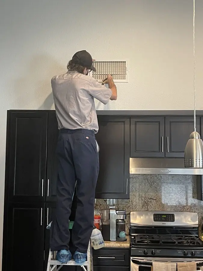 Technician inspecting an air vent during HVAC service in Mira Monte